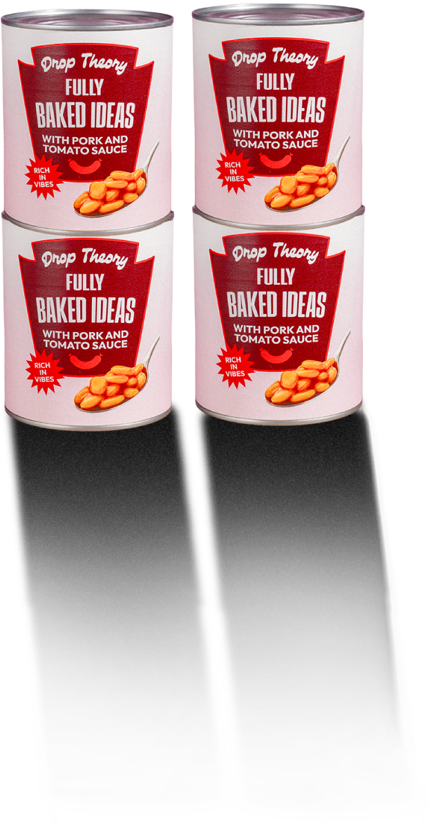Four cans labeled “Drop Theory Fully Baked Ideas with Pork and Tomato Sauce” arranged in a grid against a pink tiled background